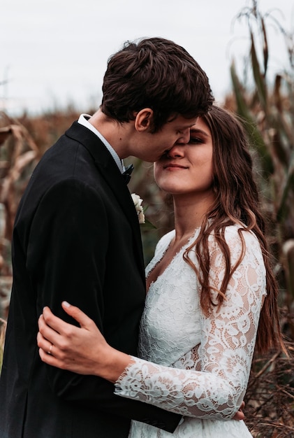 groom kissing bride while standing outdoors