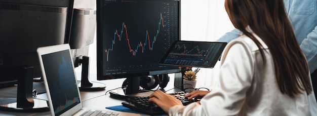 Group of traders discussing on office desk monitoring stock market on monitor at office workplace Businessman and broker analyzing stock graph together at stock trading company Trailblazing