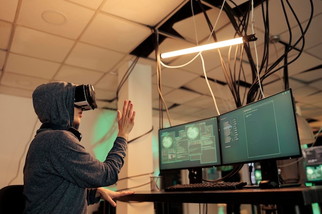 Hacker coding script in vr headset, cracking password in metaverse and hacking online server. Young woman stealing sensitive information with virtual reality glasses, cyberterrorism.