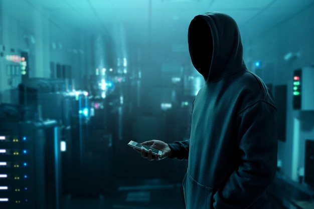 Hacker holding mobile phone