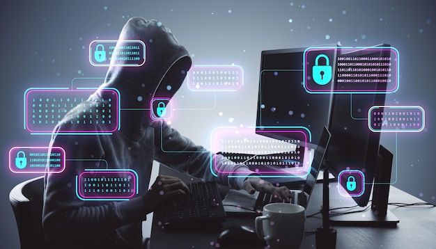 hacker in a hoodie working at a desk with glowing locks and binary codes around them