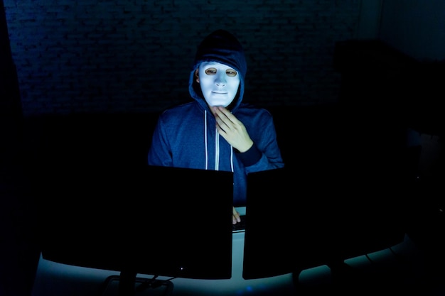 Hacker in front of computers in darkroom