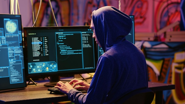 Hacker in graffiti painted hideaway