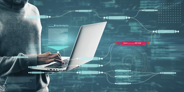 hacker in hoodie using laptop with abstract glowing big data blockchain interface on dark background cryptocurrency finance big data and information concept double exposure