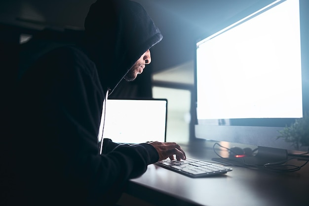 Hacker man and cyber crime with blank screen and computer for security hacking and coding Online criminal and fraud with data breach malware and digital program for identity theft with tech
