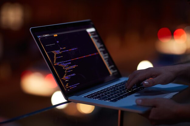 Hacker programming and laptop with hands of person for ransomware cyber security and phishing Coding technology and crime with closeup of programmer for fraud network system and data at night