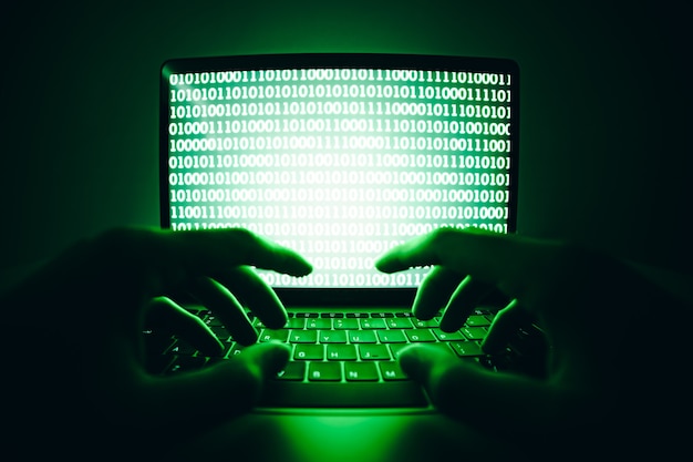 hacker using laptop to coding virus or malware for hacking internet server Cyber attack
