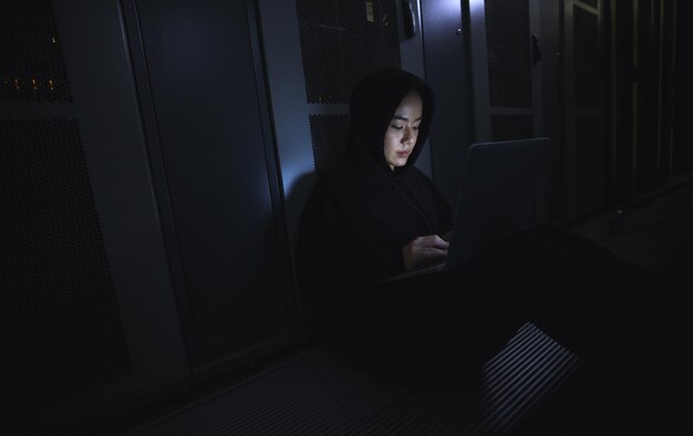 Hacking laptop and hacker woman in dark server room for coding software data center crime or cyberpunk intel Network criminal person or user in cybersecurity information technology or ransomware