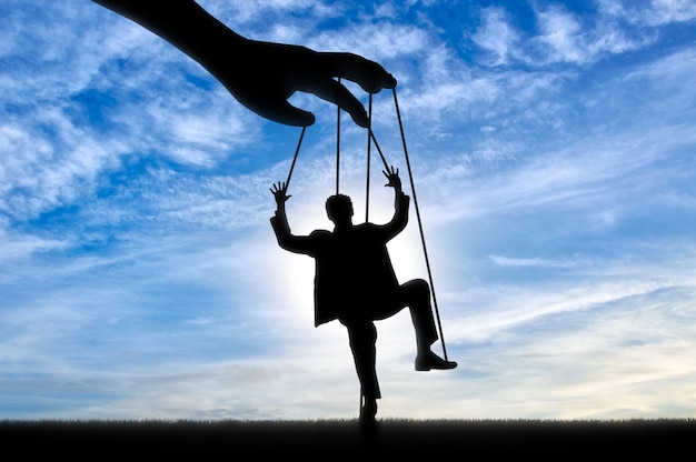 Hand controls man marionette. Manipulation concept