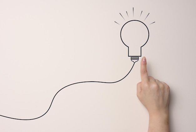 hand hold light bulb concept of the business idea innovation brainstorming inspiration and solution concepts beige background