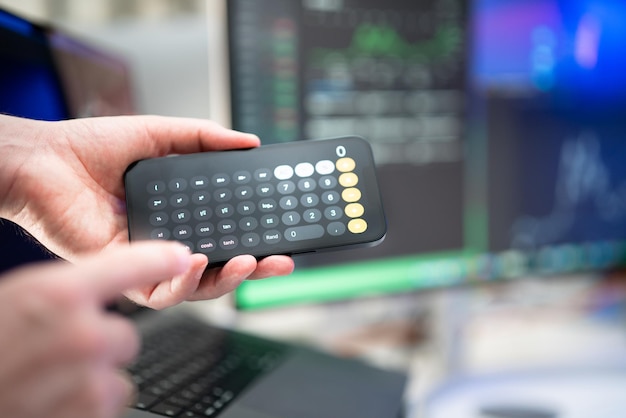 Hand holding advanced calculator Business finance office space interior