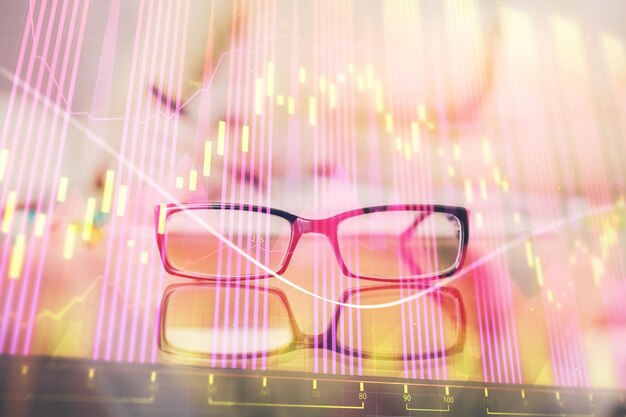 Hand taking notes in notepad Forex chart holograms in front Concept of research Double exposure