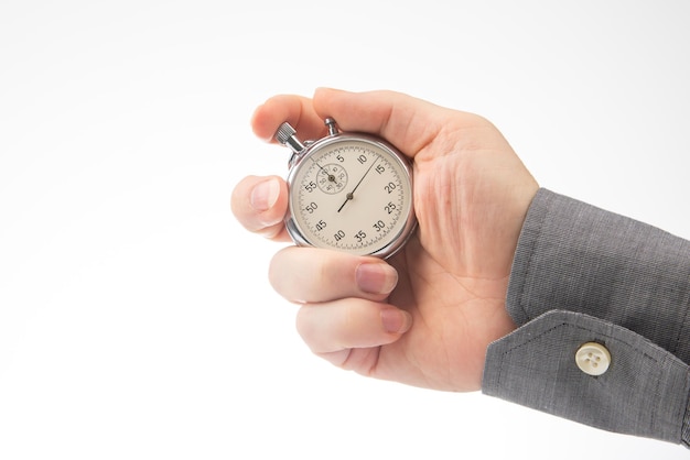hand with a mechanical analog stopwatch on a white background