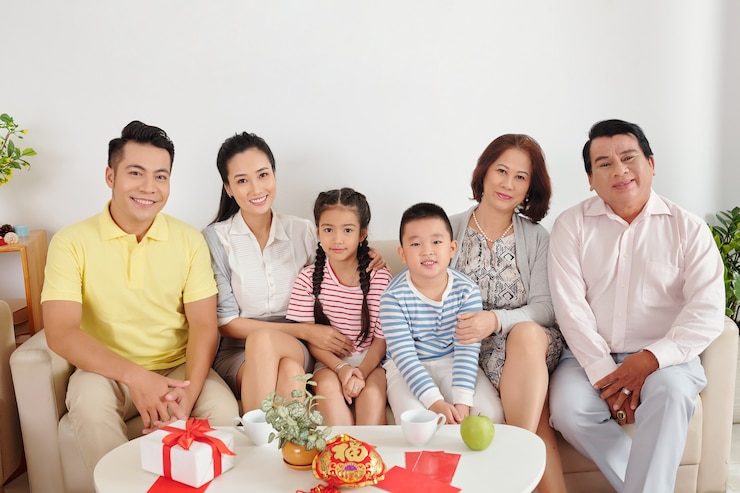 Photo happy big vietnamese family sitting on sofa in living room when celebrating lunar new year at home
