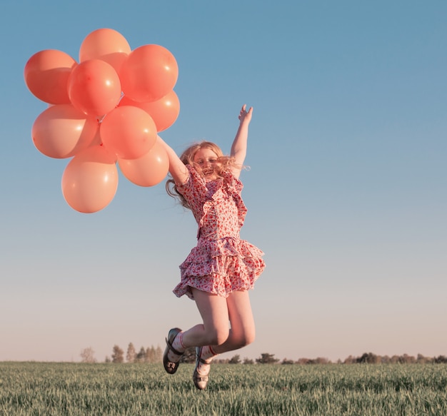 happy girl with orange balloons outdoor