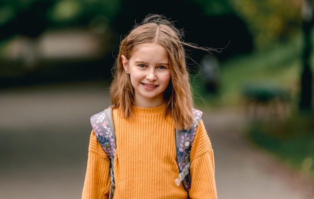 happy school girl with backpack portrait outdoors. portrait of schoolchild at autumn at the street