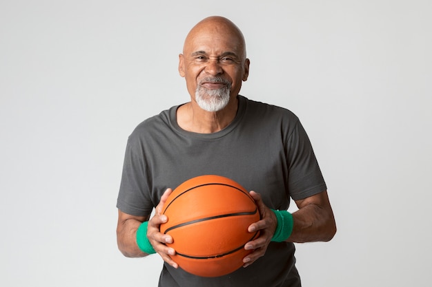 happy senior man holding a basketba