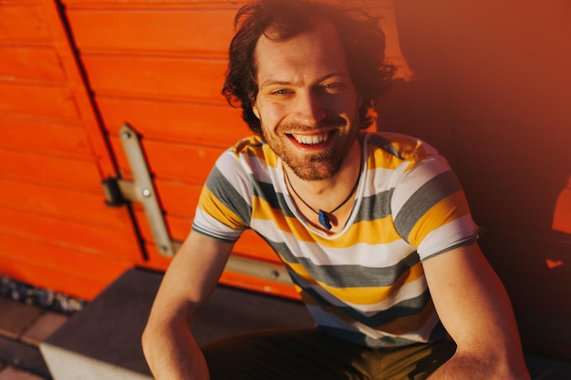 high angle portrait of man sitting against wall