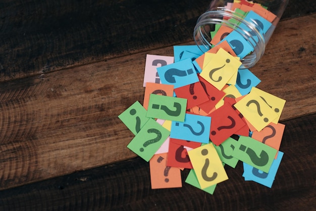High angle view of question marks on colorful adhesive notes at table