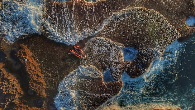 High angle view of women lying on shore at beach during sunset