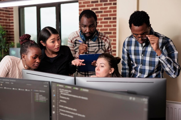 Informational agency multiracial tech engineers programming application while using computer. Cyber security company developers encrypting cloud processing data system using blockchain technology.