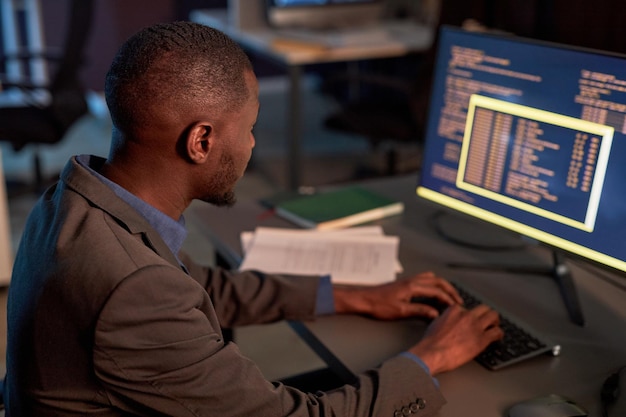 it developer wearing suit and using computer while working in office