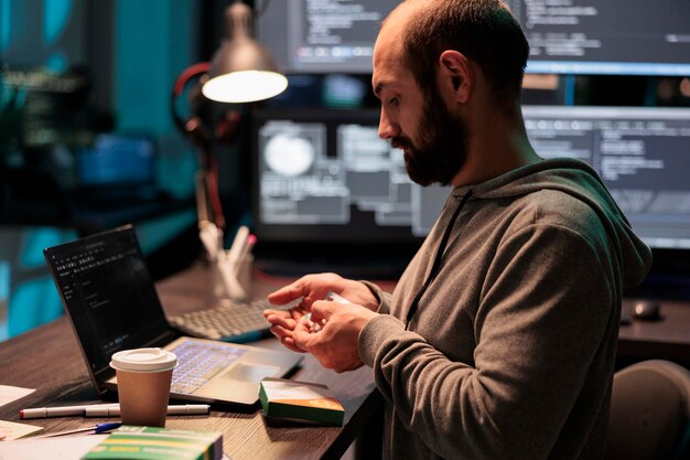 it engineer taking vitamins and working after hours, using medicine and supplements to stop being tired or stressed. taking medicaments from foil and box, programming source code.