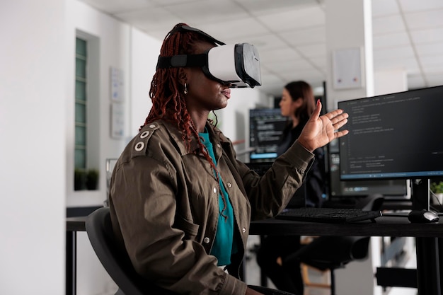 It programmer working with virtual reality headset to develop server app in it big data office, using source code. Checking programming language on cloud computing database, web developer.