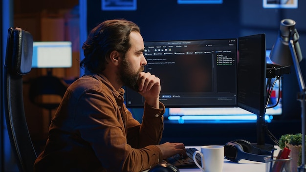 IT specialist sitting at computer desk working on desktop PC