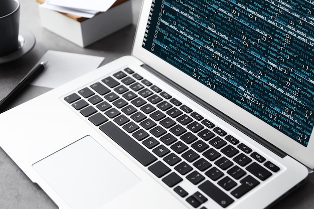 Laptop of programmer with script code on display