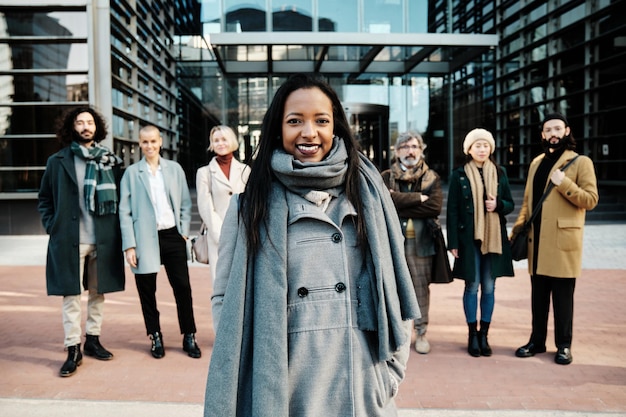 leading businesswoman standing out from a group of business people while standing together in financial district.