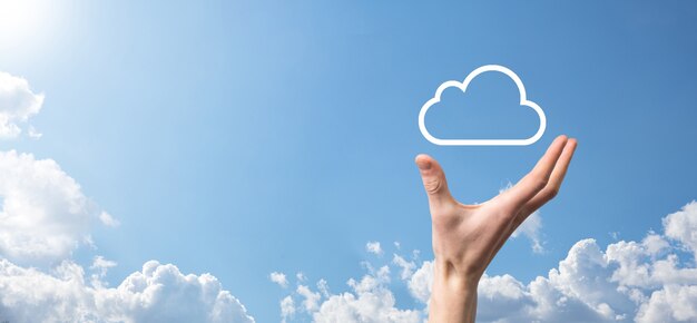 Male hand holding house icon on blue background. Property insurance and security concept.Real estate concept.Weather conditions, cloudiness.Banner with copy space.