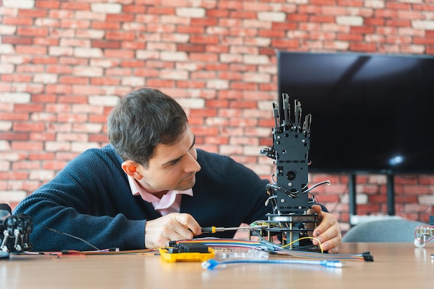 Man Assembles Bionic Hand Prototype Robotics Engineer Working on Advanced Prosthetic Arm Scientist Developing Robotic Limb Innovation in Progress