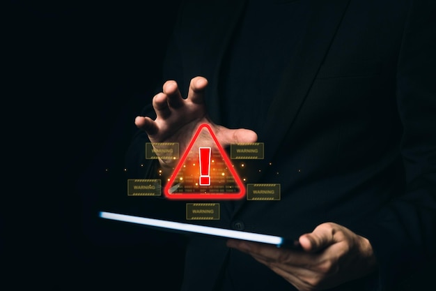 Man hand holding tablet protecting system warning caution sign for notification error Cyber attack