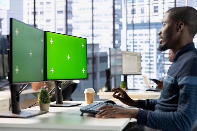 man in office looking through online business documents on green screen computer