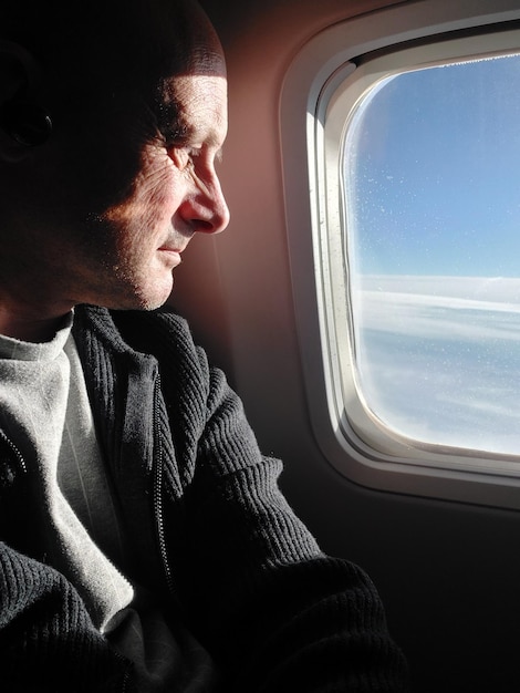 Man on aircraft looking out of window