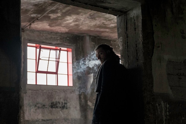 man smoking in abandoned building