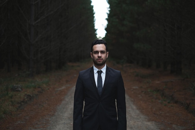 man wearing suit in forest