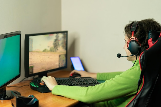 man working on table gamer playing at the computer