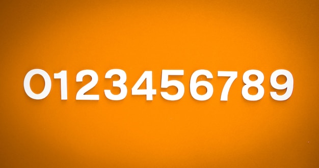 mathematics background made with solid numbers from 1 to 9 on a orange blackboard