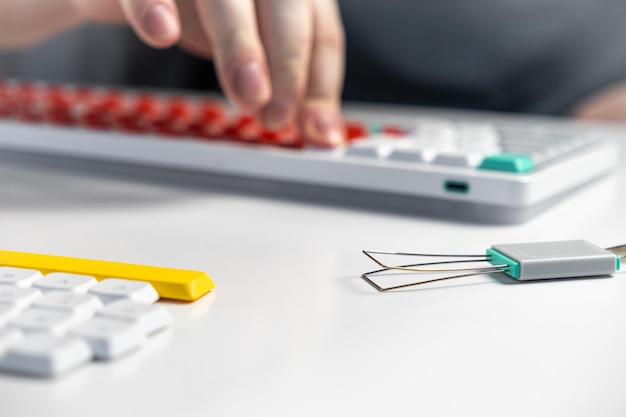 Mechanical keyboard enthusiast using keycap puller tool for custom switch replacement setup