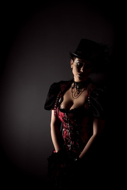mid adult woman in dress standing against black background