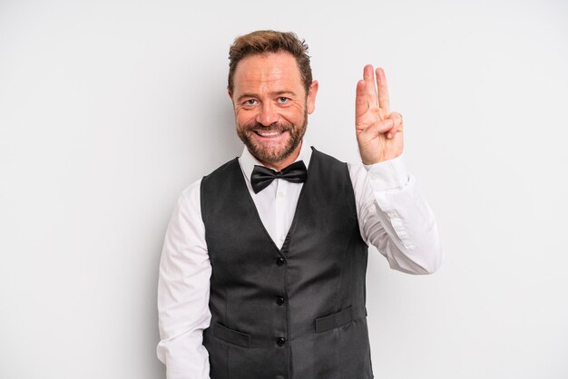 Middle age man smiling and looking friendly, showing number three. waiter concept