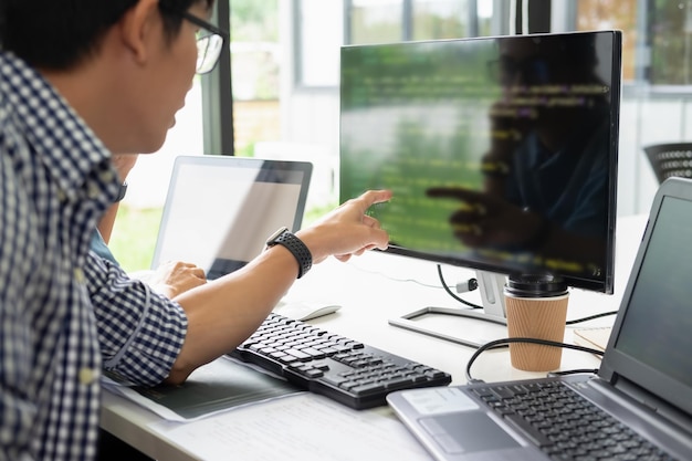 Midsection of businessman pointing at computer