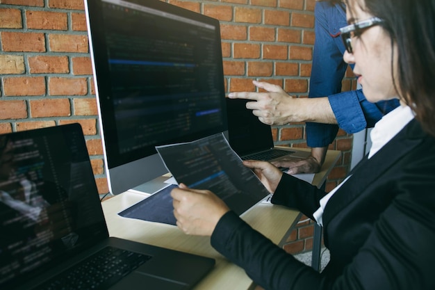Midsection of businesswoman reading paper at desk in office