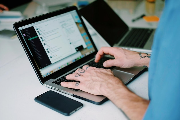 midsection of man using laptop on table