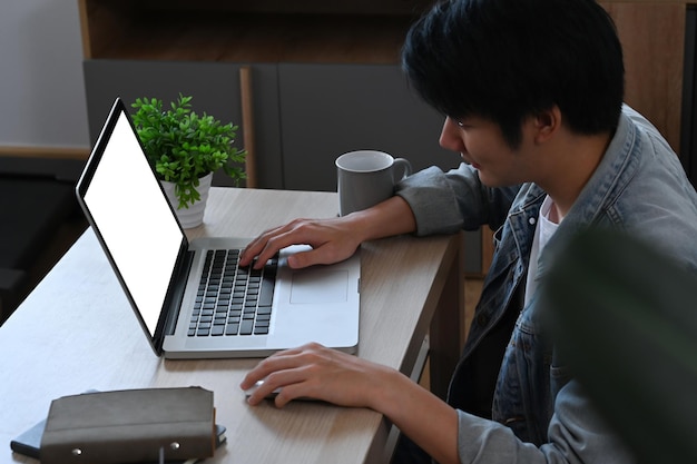 Millennial male working online checking email on laptop computer in morning at home
