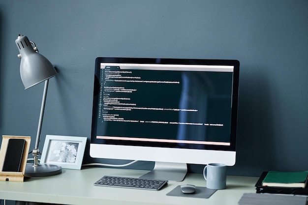 Modern desktop computer displaying programming code in minimalist workspace