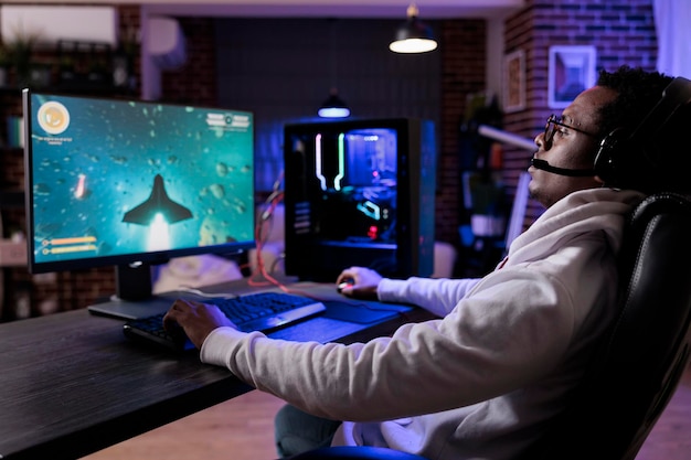 modern player live streaming shooter video games on computer, broadcasting multiplayer action gameplay tournament. young male streamer playing online game championship with equipment.