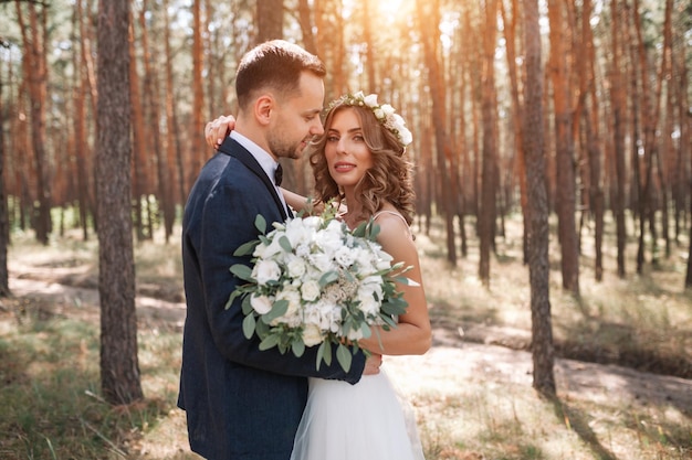newlywed couple standing in forest